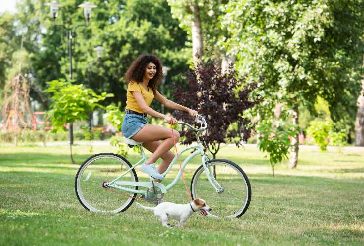 Ragazza in bici con il cane